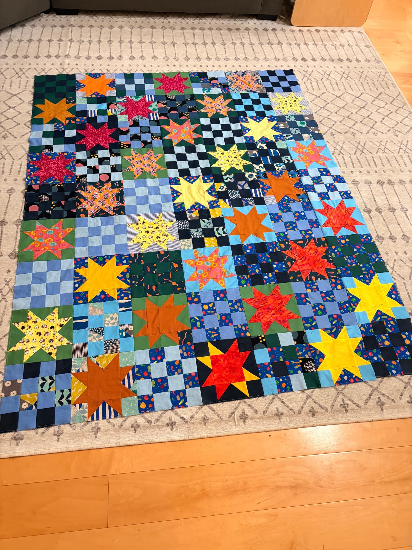 A throw-sized quilt made of scrap fabrics with stars and 16-square blocks