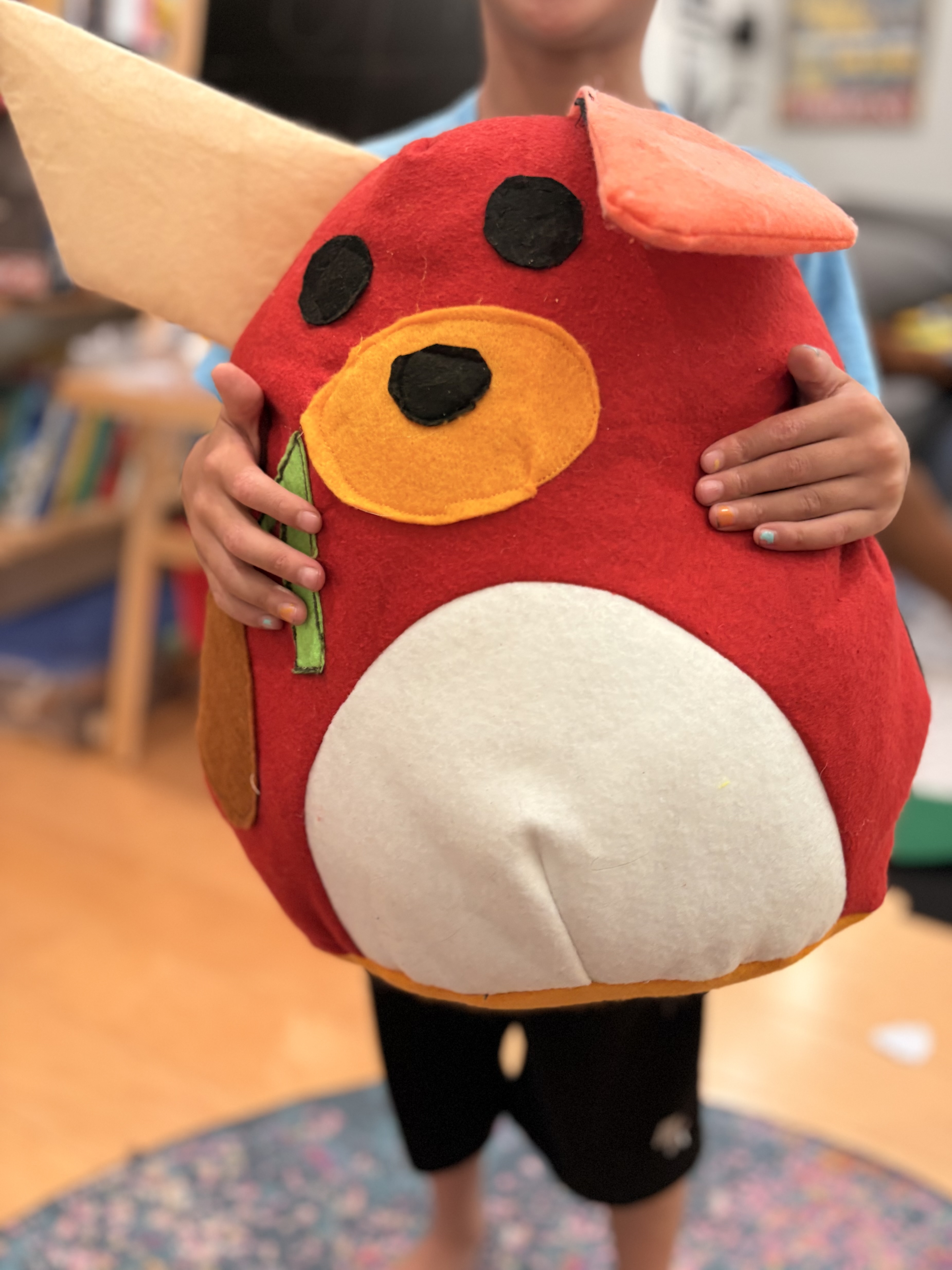 Large red, round stuffed animal with a white belly